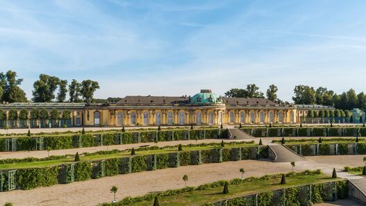Blick auf das Schloss Sanssouci im Sonnenschein, im Vordergrund die Terrassen